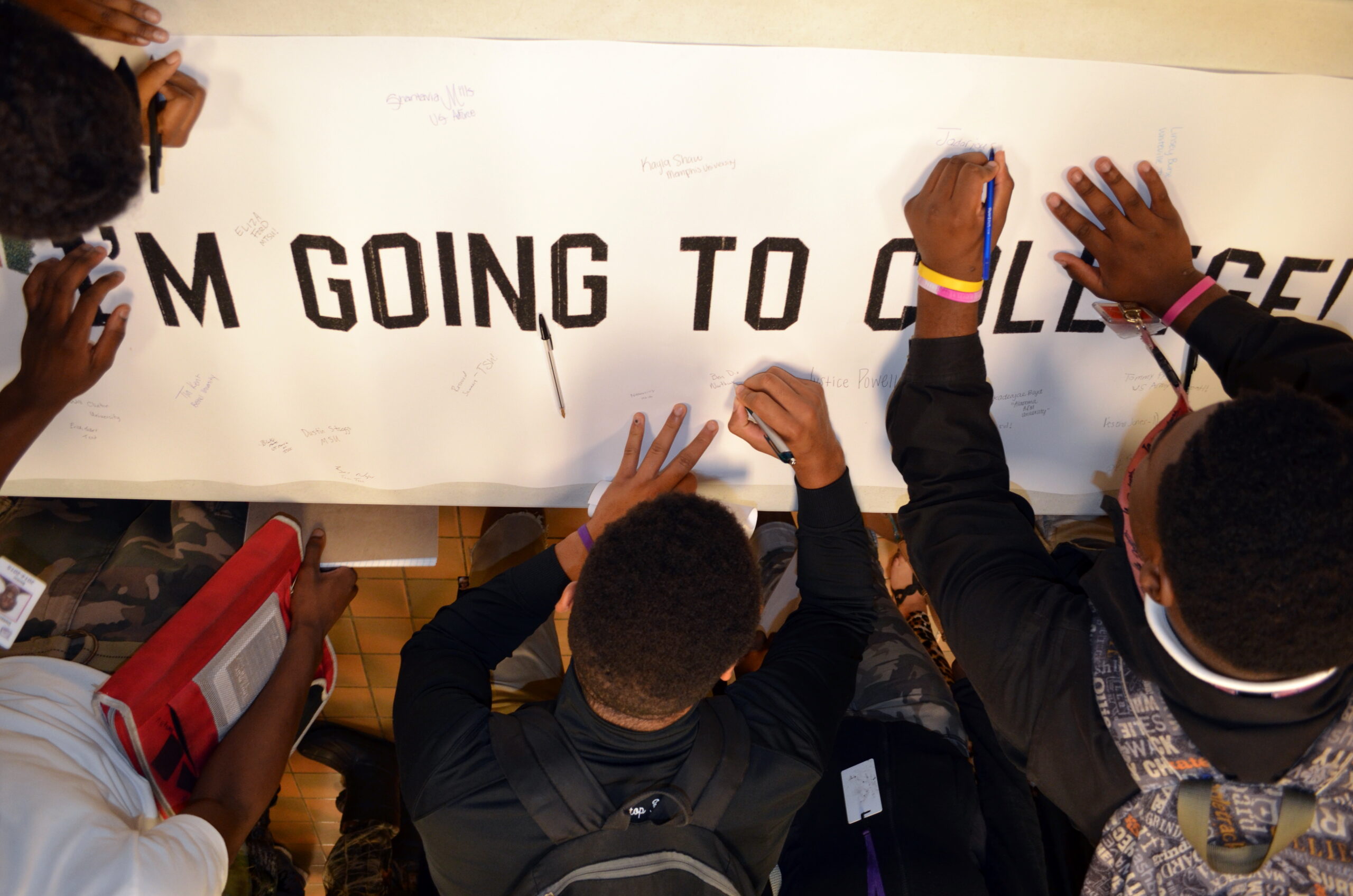students writing on a banner